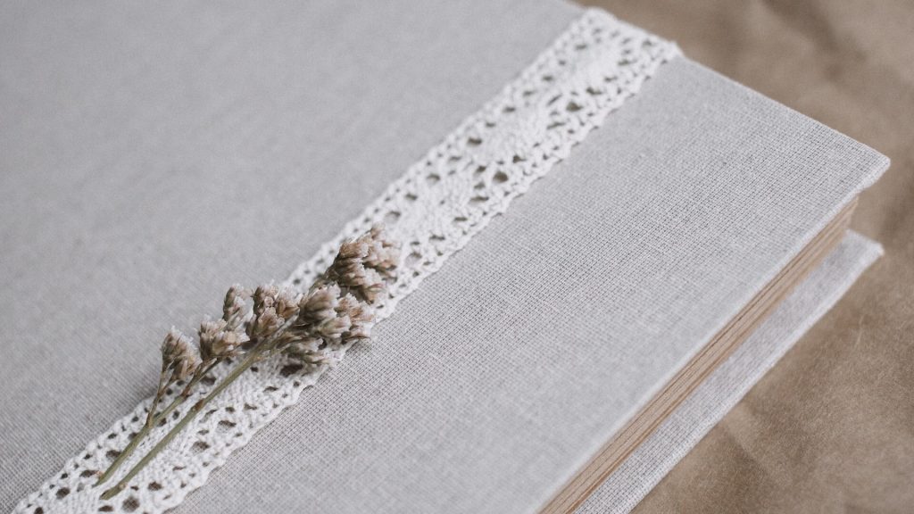 Une couverture de scrapbooking réalisée de manière créative avec du tissu et des accents de dentelle.